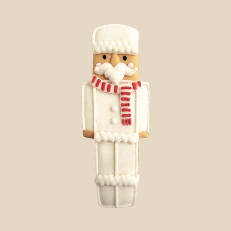 Biscuit en forme de soldat casse-noisette, décor blanc avec écharpe rouge et blanche.