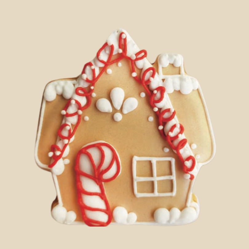Biscuit en forme de maison en pain d’épices décoré de glaçage blanc et rouge.