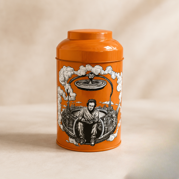 Boîte à thé en métal orange illustrée, décor graphique noir et blanc, sur fond clair.