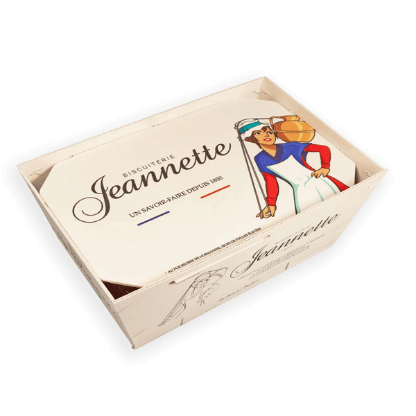 Coffret en bois de la biscuiterie Jeannette, affichant une illustration vintage d’une femme en habit traditionnel portant un panier de madeleines. Le packaging mentionne ‘Un savoir-faire depuis 1850’, avec des couleurs rappelant le drapeau français.