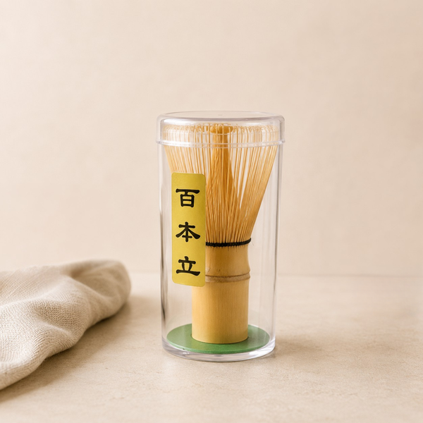 Fouet à matcha en bambou dans son étui transparent, accessoire traditionnel pour la préparation du thé matcha.