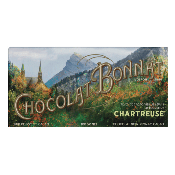Tablette de chocolat noir Bonnat Chartreuse 75 % cacao. L'emballage présente un paysage de montagnes et d’un monastère au milieu de la verdure. "Chocolat Bonnat" est écrit en grande typographie dorée au centre. En bas à droite, une mention en petits caractères précise que les fèves de cacao sont vieillies dans un foudre de Chartreuse.