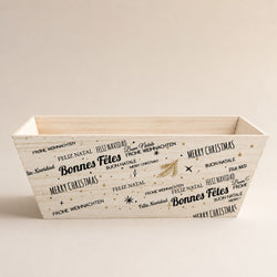 Corbeille cadeau de Noël en bois décorée de messages festifs multilingues, idéale pour coffrets gourmands et paniers garnis.
