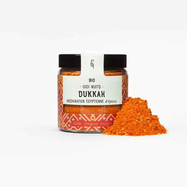 Pot de mélange d’épices Dukkah bio SoulSpice, poudre rouge orangé avec graines, étiquette rouge à motifs géométriques.