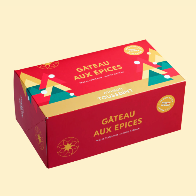 Gâteau aux épices Maison Toussaint dans une boîte rouge festive.