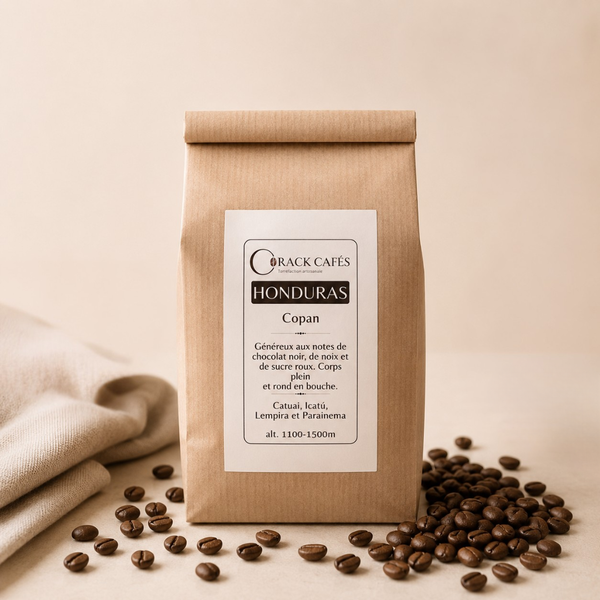 Café en grains Honduras Copán en sachet kraft, avec grains de café dispersés sur fond clair. Crack Cafés.