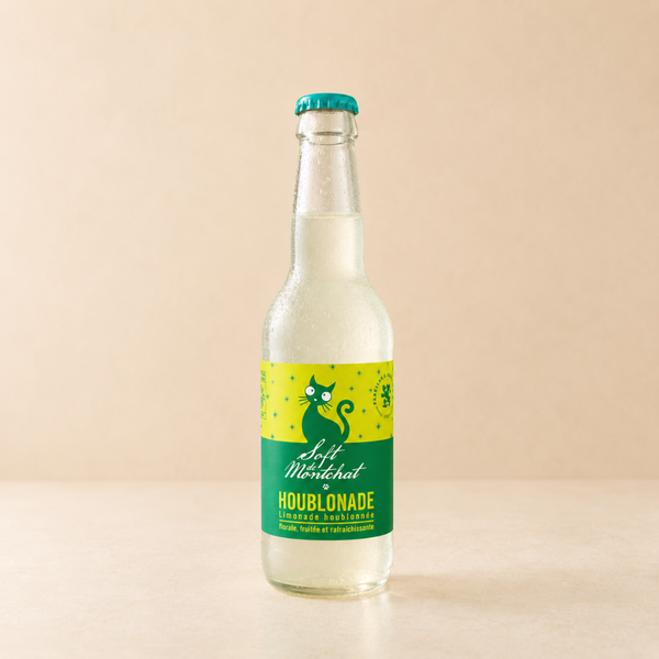 Limonade houblonnée en bouteille en verre, boisson pétillante artisanale, étiquette verte et jaune, fond clair.