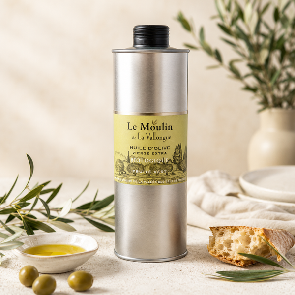 Huile d’olive vierge extra biologique fruité vert en bidon métallique, présentée avec olives, pain et branches d’olivier.