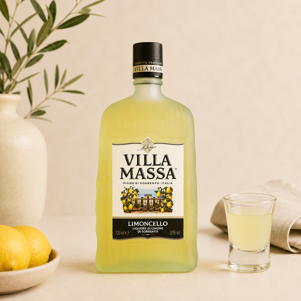 Limoncello Villa Massa en bouteille givrée, accompagné d’un verre et de citrons, dans une ambiance méditerranéenne lumineuse.