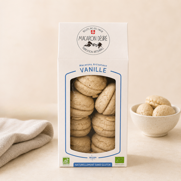 Boîte de macarons artisanaux à la vanille, de fabrication française et certifiée bio, naturellement sans gluten. Les macarons sont visibles à travers une fenêtre transparente sur le devant de l'emballage.