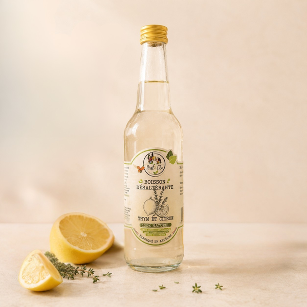 Bouteille en verre d’infusion glacée au thym et citron, de marque Mat&Elo. L’étiquette ovale blanche indique ‘100% naturel, sans colorant, sans conservateur’ avec une illustration de thym et d’un citron. Le liquide est d’une teinte jaune pâle. 