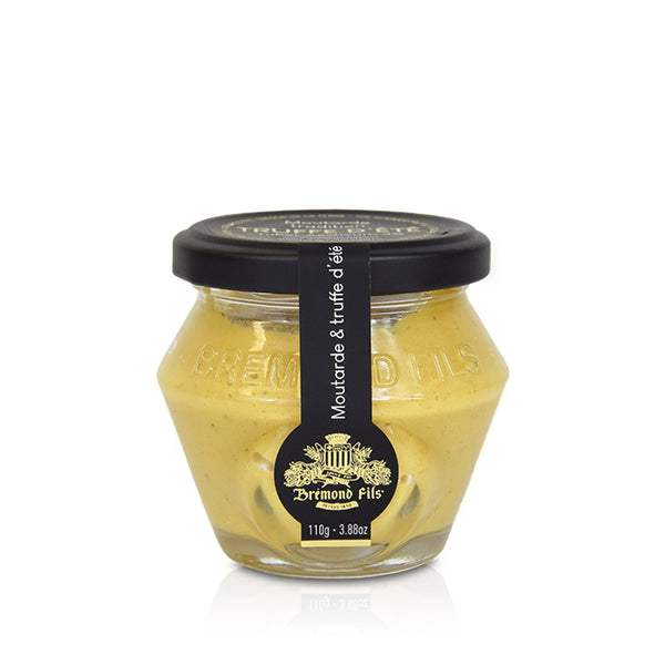 Moutarde à la truffe d’été en pot en verre, texture crémeuse jaune pâle, couvercle noir et étiquette élégante.