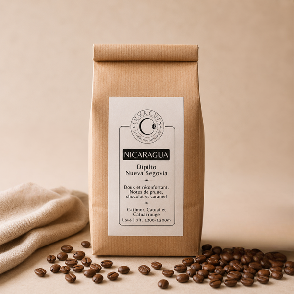 Sachet de café en grains Nicaragua Crack Cafés, emballage kraft avec étiquette blanche, posé sur fond clair avec grains de café.