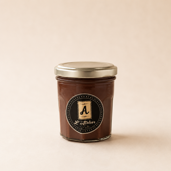 Pâte à tartiner artisanale au chocolat l'Atelier de Sabine en pot en verre, texture gourmande et étiquette noire élégante.
