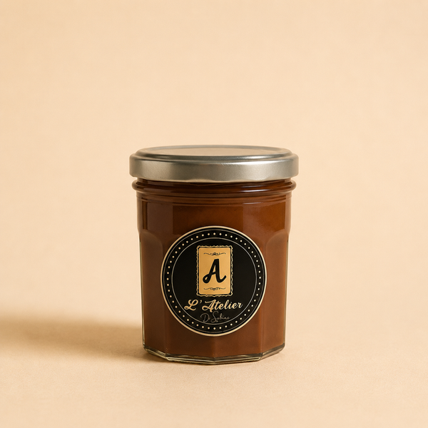 Pot en verre L’Atelier de Sabine contenant une pâte à tartiner gourmande marron, avec couvercle argenté et étiquette noire. 