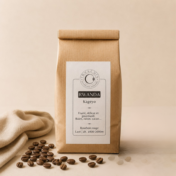 Sachet de café en grains Rwanda Kageyo Crack Cafés, emballage kraft avec étiquette blanche, posé sur fond clair avec grains de café.