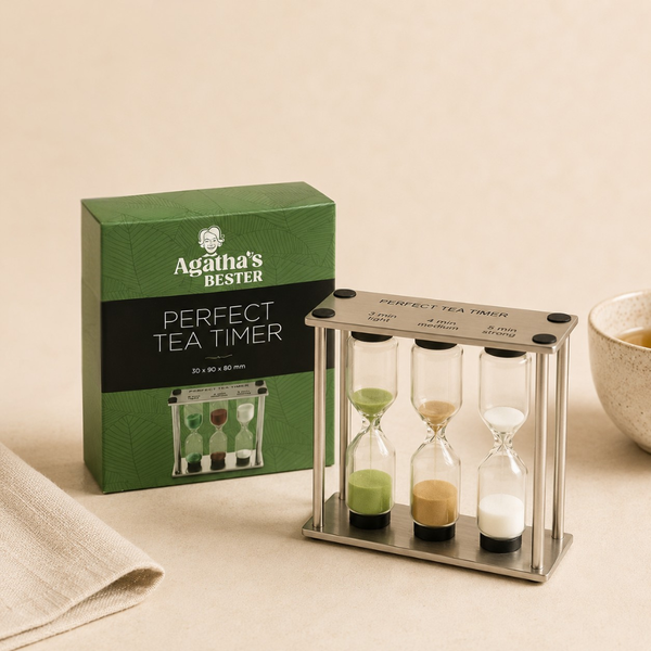 Sablier à thé triple en acier inoxydable avec trois minuteries et boîte Agatha's Bester sur fond clair.
