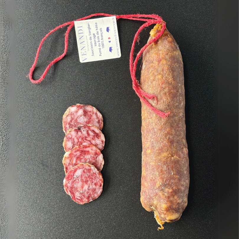 Un saucisson entier de sanglier sauvage 100 % français sur une ardoise noire, accompagné de quatre tranches. Une étiquette signée Venandi.
