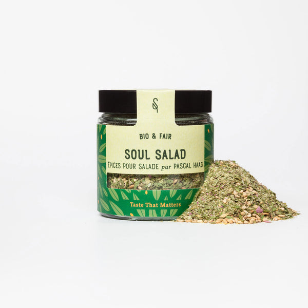 Pot d’épices bio pour salades SoulSpice, mélange coloré avec graines, étiquette verte à motifs feuillus.