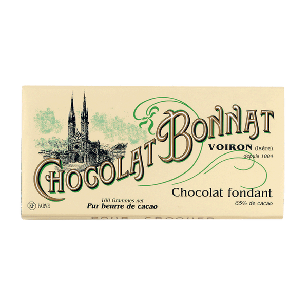 Tablette de chocolat noir Bonnat fondant 65% cacao. L'emballage est beige clair, avec "Chocolat Bonnat" écrit en grande typographie marron et verte au centre. Une illustration en noir d'une cathédrale est située sur la gauche. À droite, des mentions en petits caractères indiquent qu'il s'agit de chocolat fondant avec 65% de cacao, d'un poids de 100 grammes, et pur beurre de cacao.