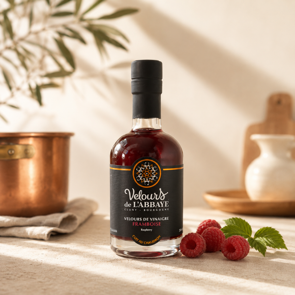 Velours de vinaigre à la framboise en bouteille élégante, présenté avec framboises fraîches dans une ambiance cuisine chaleureuse