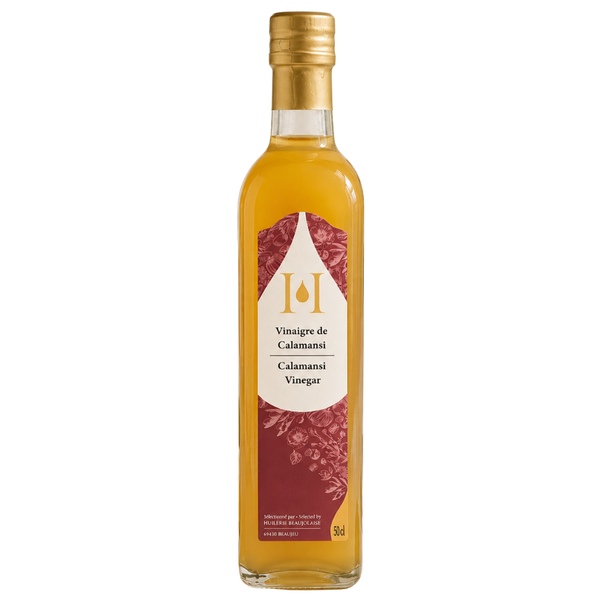 Vinaigre de calamansi en bouteille verre sur fond blanc.