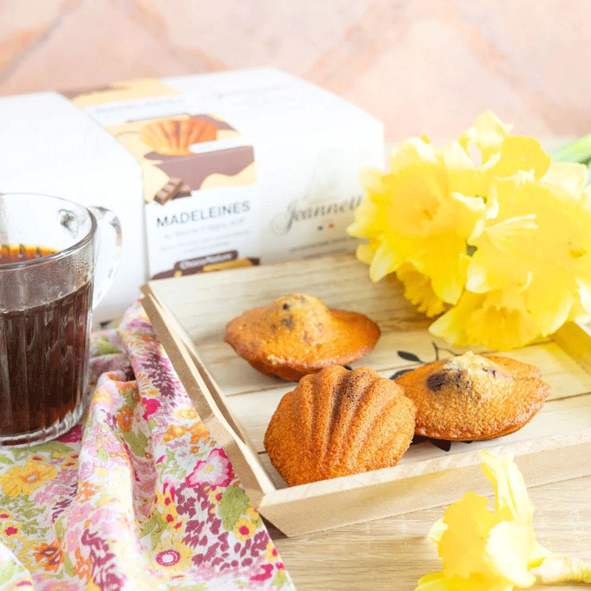 Plateau avec madeleines Jeannette, tasse de café et fleurs jaunes, ambiance petit-déjeuner printanier.