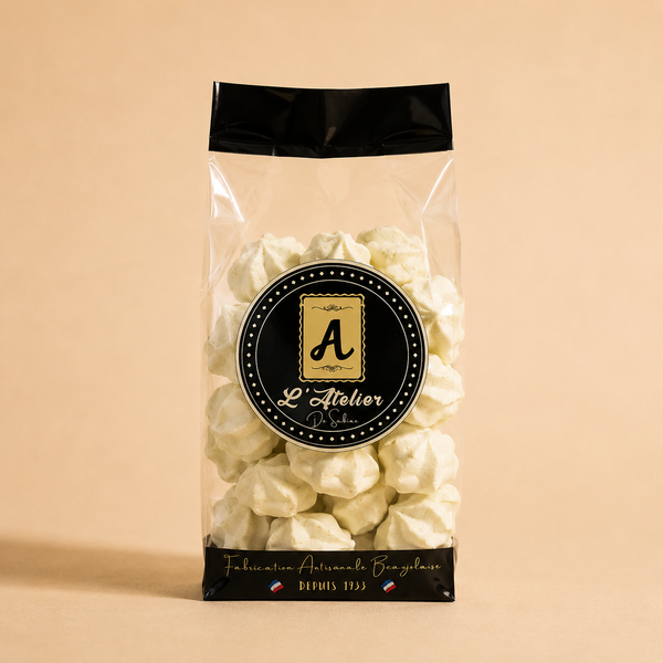 Sachet transparent de meringues vert pâle artisanales L’Atelier de Sabine, avec étiquette noire et emballage élégant.